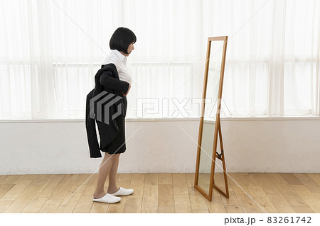 姿見の前でジャケットを着る女性 姿見の前でジャケットを着る女性 83261742