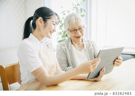 タブレットを使うエプロン姿の女性と高齢者女性 83262483
