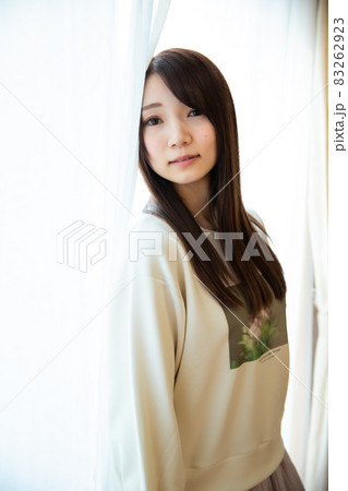 カーテンの前でポージングをしている若い日本人女性 カーテンの前でポージングをしている若い日本人女性 83262923