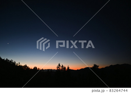 地平線へと沈む燃える太陽と北アルプスの山々 83264744