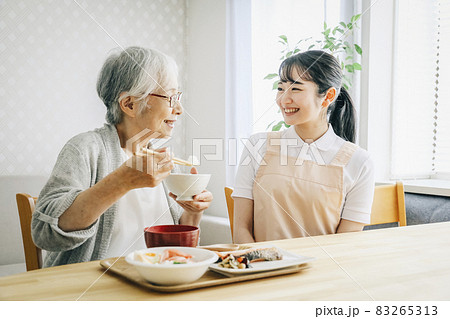 食事介助する女性スタッフ 83265313