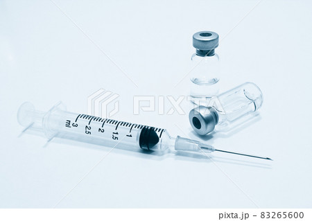 Vial of drugs or vaccine and 3 ml plastic syringe with needle isolated on the white background, blue tone color Vial of drugs or vaccine and 3 ml plastic syringe with needle isolated on the white background, blue tone color 83265600