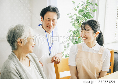高齢者と話す男女のスタッフ 83265654