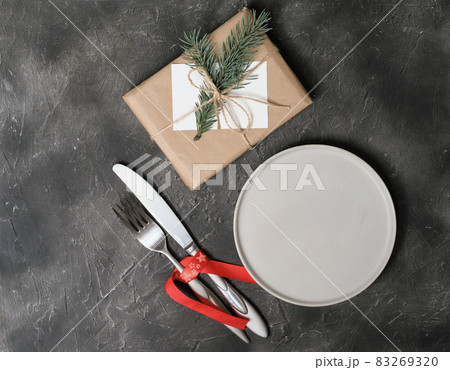 empty plate with tableware and christmas decor on grey table. copy space. table setting template for new year or christmas menu. restaurant menu mock up. top view 83269320