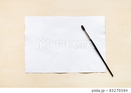 paintbrush and blank sheet of white textured paper paintbrush and blank sheet of white textured paper 83270394