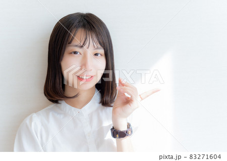 左手で指をさす笑顔の女性 左手で指をさす笑顔の女性 83271604