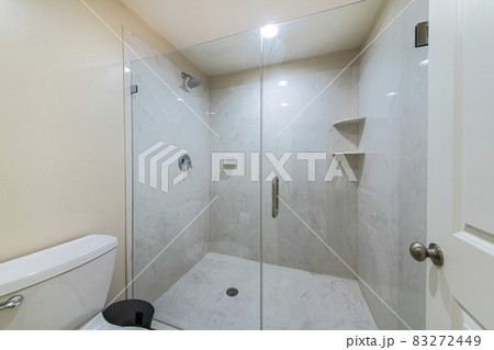 Interior of a bathroom with frameless shower stall 83272449