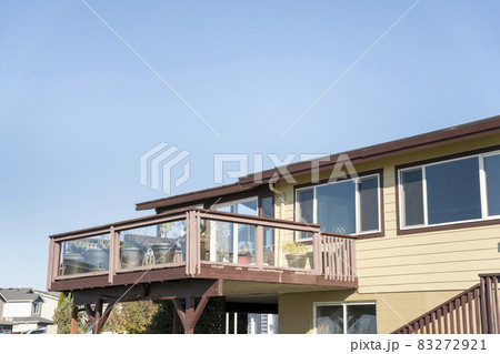 Terrace of a house with wooden handrails and glass panel 83272921