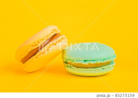 Sweet almond colorful unicorn blue yellow macaron or macaroon dessert cake isolated on trendy yellow modern fashion background. French sweet cookie. Minimal food bakery concept Copy space Sweet almond colorful unicorn blue yellow macaron or macaroon dessert cake isolated on trendy yellow modern fashion background. French sweet cookie. Minimal food bakery concept Copy space 83273159