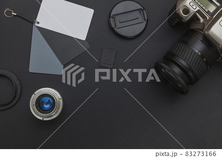 Photographer workplace with dslr camera system, camera cleaning kit, lens and camera accessory on dark black table background. Hobby travel photography concept Flat lay top view copy space 83273166