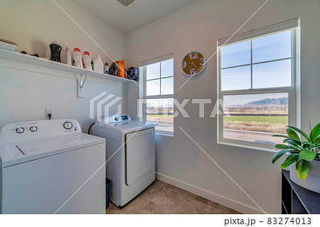 Functional laundry room with modern appliances and view of scenic outdoors 83274013