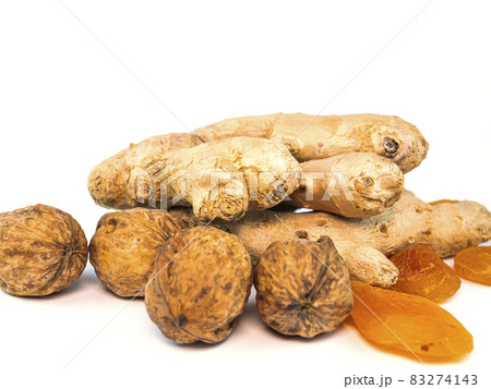 Ginger root with walnuts and dried apricots apricots on a white background. 83274143
