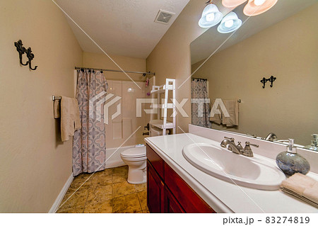 Bathtub sink toilet mirror tiles and shower curtain inside bathroom of a home Bathtub sink toilet mirror tiles and shower curtain inside bathroom of a home 83274819