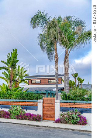 Wooden gate and fence of home in San Diego California against cloudy blue sky 83276528