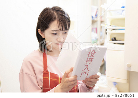 洗面所で真剣に投資の本を読む女性 83278051