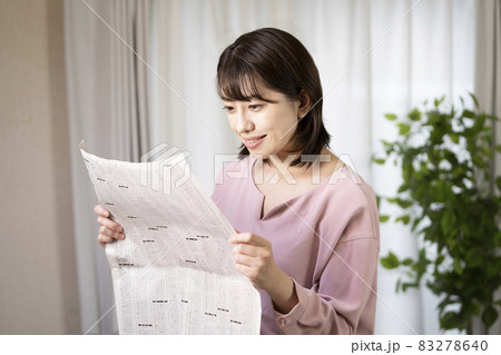 新聞の株式欄を読む女性 83278640