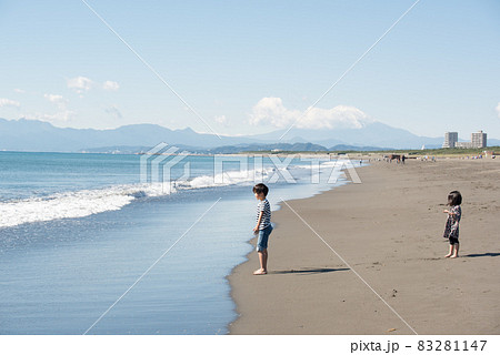 砂浜で砂遊びをする兄妹 83281147