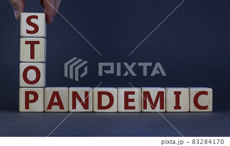 Wooden cubes with the expression 'stop pandemic'. Beautiful grey background, male hand. Medical and covid-19 pandemic concept, copy space. 83284170