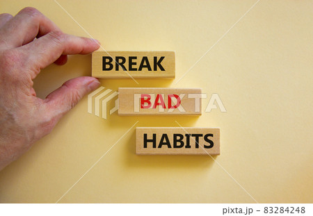Break bad habits symbol. Wooden blocks with words 'break bad habits'. Businessman hand. Beautiful white background, copy space. Business, psychological and break bad habits concept. Break bad habits symbol. Wooden blocks with words 'break bad habits'. Businessman hand. Beautiful white background, copy space. Business, psychological and break bad habits concept. 83284248