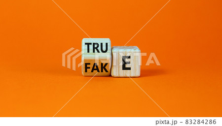Fake or true symbol. Turned a wooden cube and changed the word 'fake' to 'true' or vice versa. Beautiful orange table, orange background, copy space. Business and fake or true concept. Fake or true symbol. Turned a wooden cube and changed the word 'fake' to 'true' or vice versa. Beautiful orange table, orange background, copy space. Business and fake or true concept. 83284286