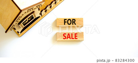 House for sale symbol. Concept words 'For sale' on wooden blocks near miniature house. Beautiful white background, copy space. Business and house for sale concept. 83284300