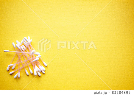a lot of cotton buds on yellow background 83284395