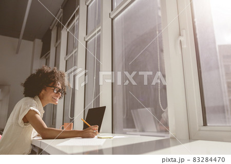 Smiling female assistance making notes in notebook 83284470