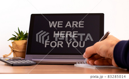 Support symbol. Tablet with words 'we are here for you'. Online business and support during COVID-19 quarantine. Businessman hand with pen, house plant. Copy space. Support concept. 83285014