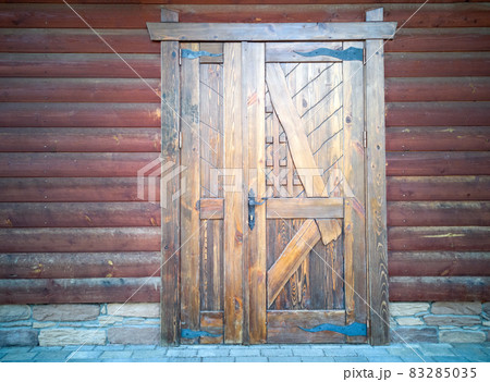 Ancient wooden door in old wooden castle wall. Beautiful background, concept. 83285035