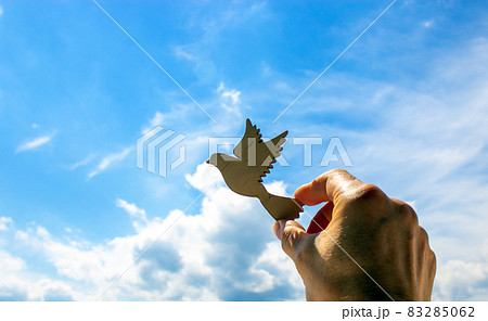Man hand holding wooden bird on cloud sky background. The development of the imagination, copy space. 83285062