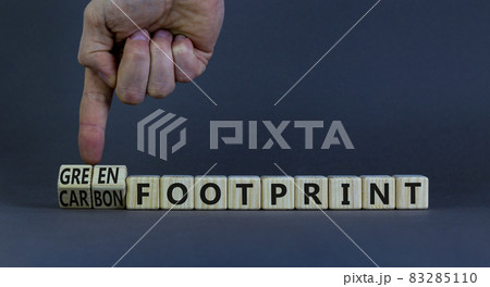 Green or carbon footprint symbol. Businessman turns wooden cubes and changes words 'carbon footprint' to 'green footprint'. Grey background, copy space. Business, green or carbon footprint concept. Green or carbon footprint symbol. Businessman turns wooden cubes and changes words 'carbon footprint' to 'green footprint'. Grey background, copy space. Business, green or carbon footprint concept. 83285110