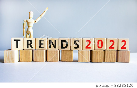 Business concept of 2022 trends symbol. Words 'Trends 2022' on wooden cubes. Wooden model of businessman. Beautiful white background. Business and trends 2021 new year concept. Copy space. 83285120