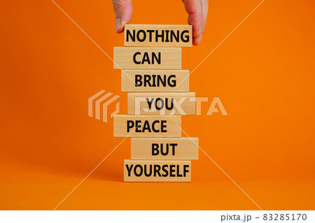 Concept of building success foundation. Businessman hand. Wooden blocks with words nothing can bring you peace but yourself. Beautiful orange background, copy space. Business and motivational concept. 83285170