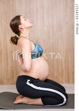 Pregnant woman doing yoga exercise meditating 83285227