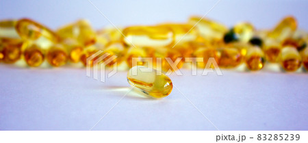 Yellow vitamins tablets, fish oil, Omega Vitamin E. Pills on a white background. Web banner with a copy space. 83285239