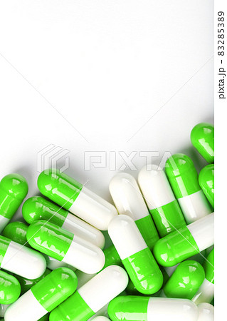 White and green pills on a white background. White and green pills on a white background. 83285389