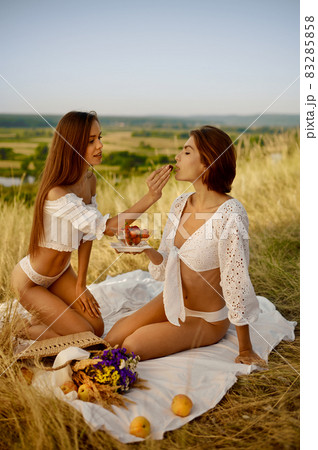Sexy women in lingerie eating strawberry in field Sexy women in lingerie eating strawberry in field 83285858