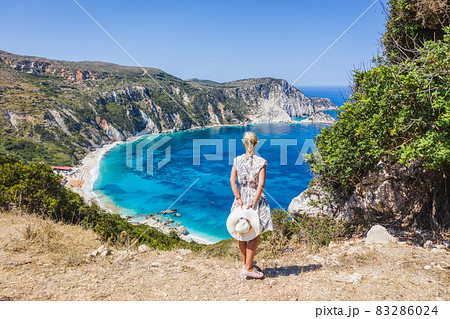 A tourist woman enjoying beautiful Petani beach on Kefalonia Ionian island, Greece, during her summer vacation holiday A tourist woman enjoying beautiful Petani beach on Kefalonia Ionian island, Greece, during her summer vacation holiday 83286024
