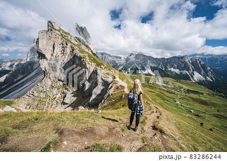 Women hiker on hiking trail path and epic landscape of Seceda peak in Dolomites Alps, Odle mountain range, South Tyrol, Italy, Europe Women hiker on hiking trail path and epic landscape of Seceda peak in Dolomites Alps, Odle mountain range, South Tyrol, Italy, Europe 83286244