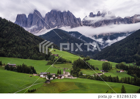St Magdalena church in Val di Funes valley, Dolomites, Italy. Furchetta and Sass Rigais mountain peaks in background 83286320