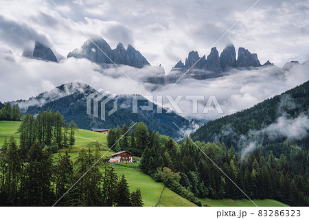 St Magdalena church in Val di Funes valley, Dolomites, Italy. Furchetta and Sass Rigais mountain peaks in background 83286323