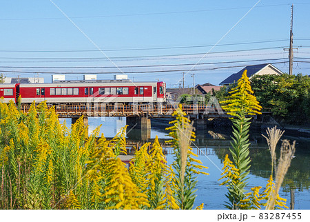 セイタカアワダチソウが咲く堀切川の河川敷を渡る近鉄列車名古屋線 83287455