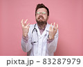 Doctor with a stethoscope around neck in stress, he bares teeth furiously and makes a gesture with 83287979