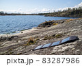 Portable solar panels lie on the stone shore of the lake and accumulate energy. Modern technologies 83287986