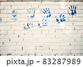 Brick white wall with blue handprints. Copy space. Great idea. Abstract background. 83287989