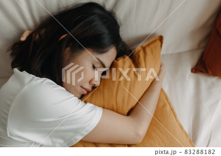 Woman is taking a nap or sleep on the sofa with yellow pillow. Woman is taking a nap or sleep on the sofa with yellow pillow. 83288182