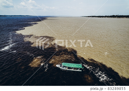 Boat with tourists on the verge of mixing rivers. Amazon. 83289855