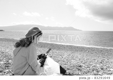 旅先の海辺で携帯を操作する女性の姿 旅先の海辺で携帯を操作する女性の姿 83291649