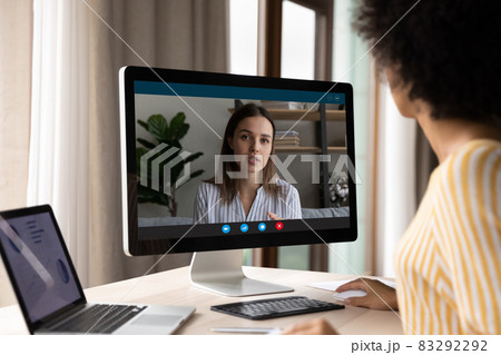 Concentrated young african ethnicity businesswoman holding video call conversation. 83292292