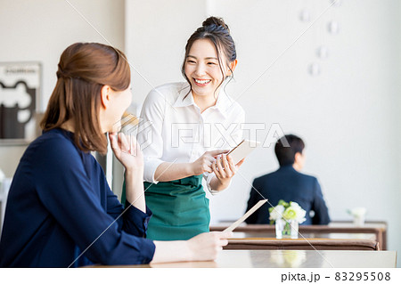 カフェで注文する若い女性 83295508